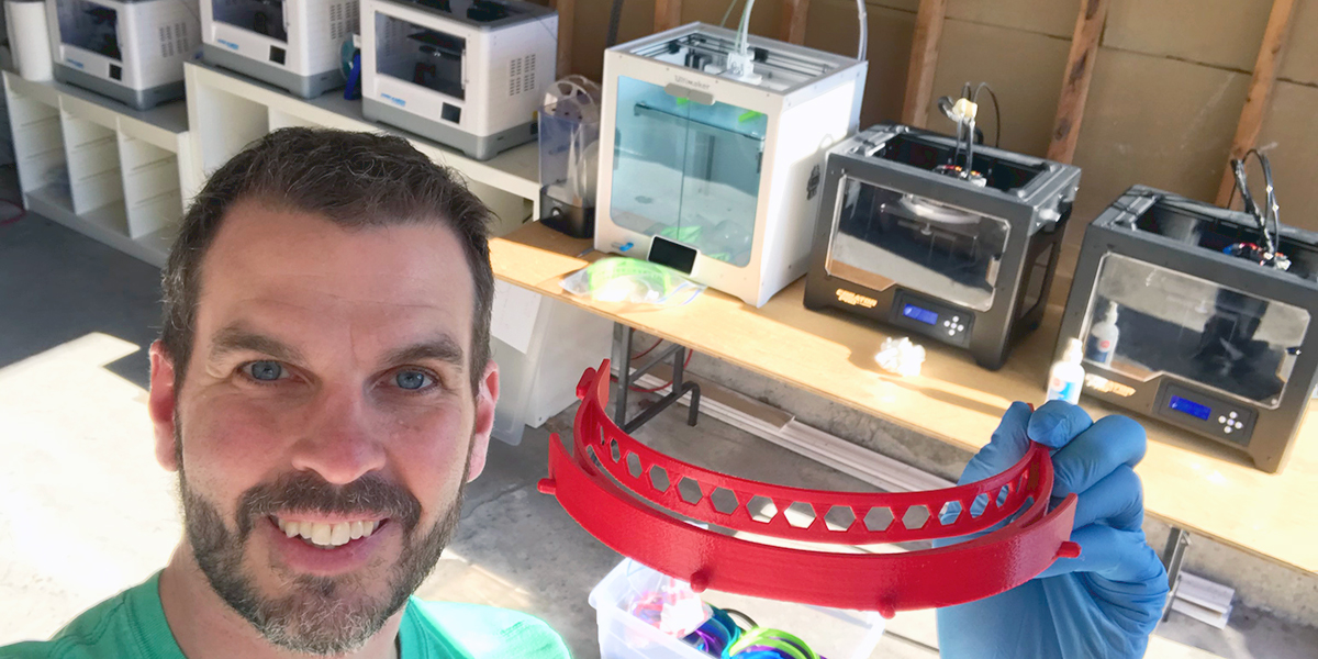 Male in front of several 3D printers