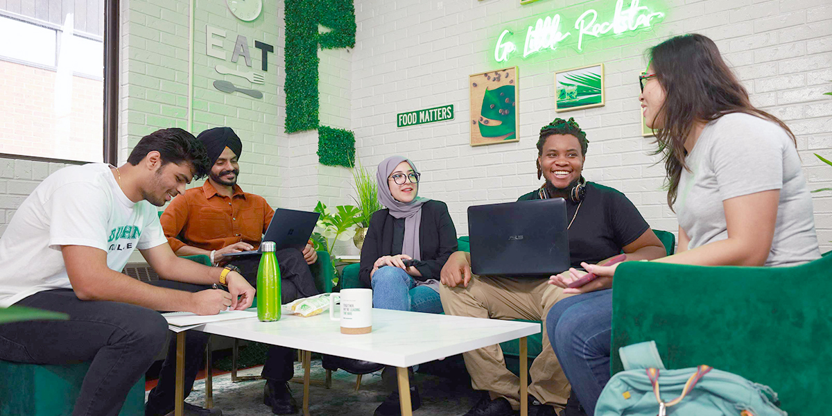 Students sit and chat while studying in the Durham College cafeteria.